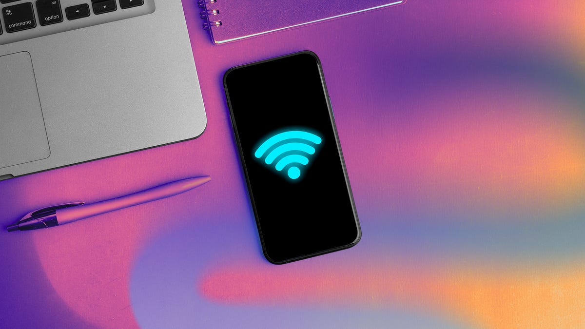 smartphone with Wi-Fi logo in neon blue next to laptop
