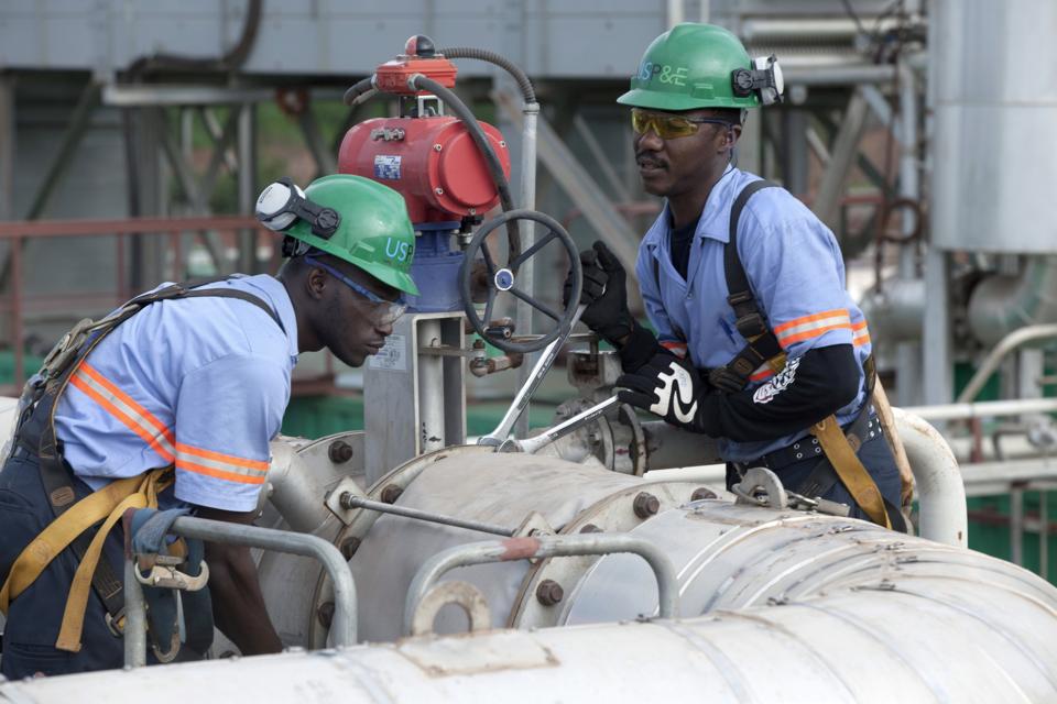 Workers service a power station in Marampa, Sierra Leone