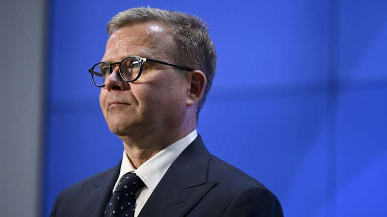 Petteri Orpo against a blue background.