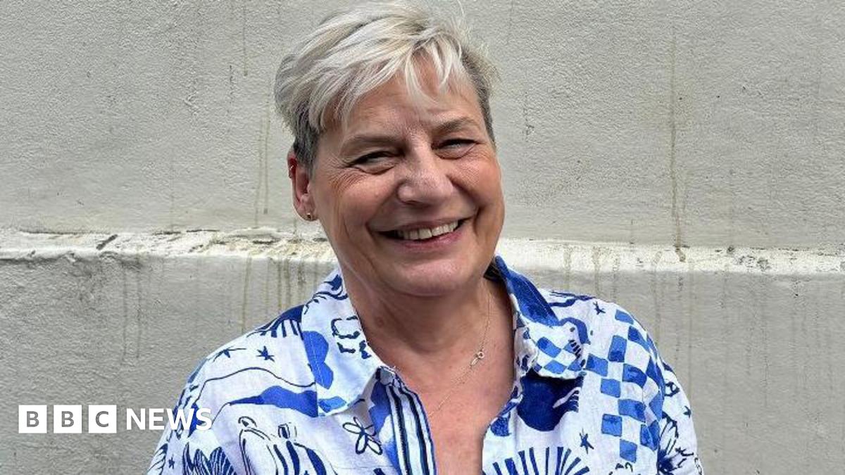 Helen Scarsbrook, smiling, in blue and white patterned shirt