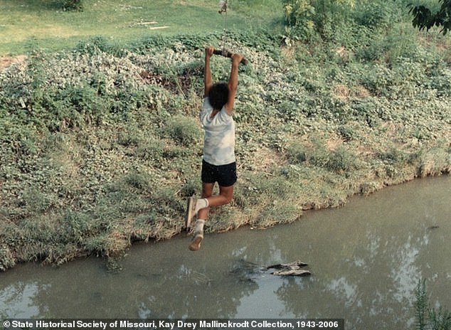 Generations of families played in Coldwater Creek which has resulted in thousands of people developing life-threatening cancers and other illnesses Pictured: A 1980s picture of a boy using a rope swing to jump into Coldwater Creek