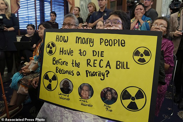 A member of the Navajo Nation holds holds a banner during a news conference about the Radiation Exposure Compensation Act on Capitol Hill in Washington