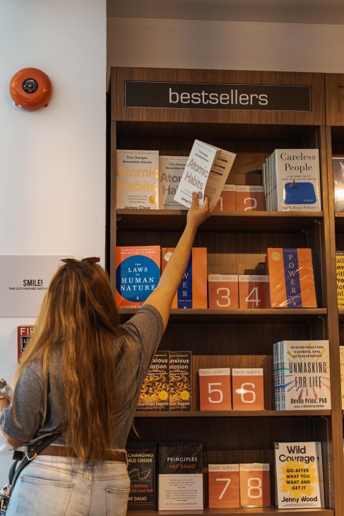 Customer reaches for a book at the Fully Booked branch in Bonifacio High Street, Manila, Philippines, on Thursday, April 17, 2025.