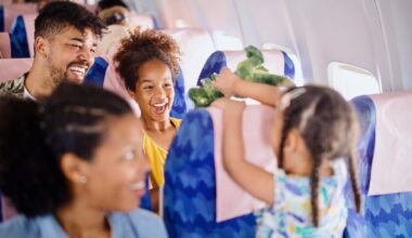 Two young girls play with stuffed animals on a plane.