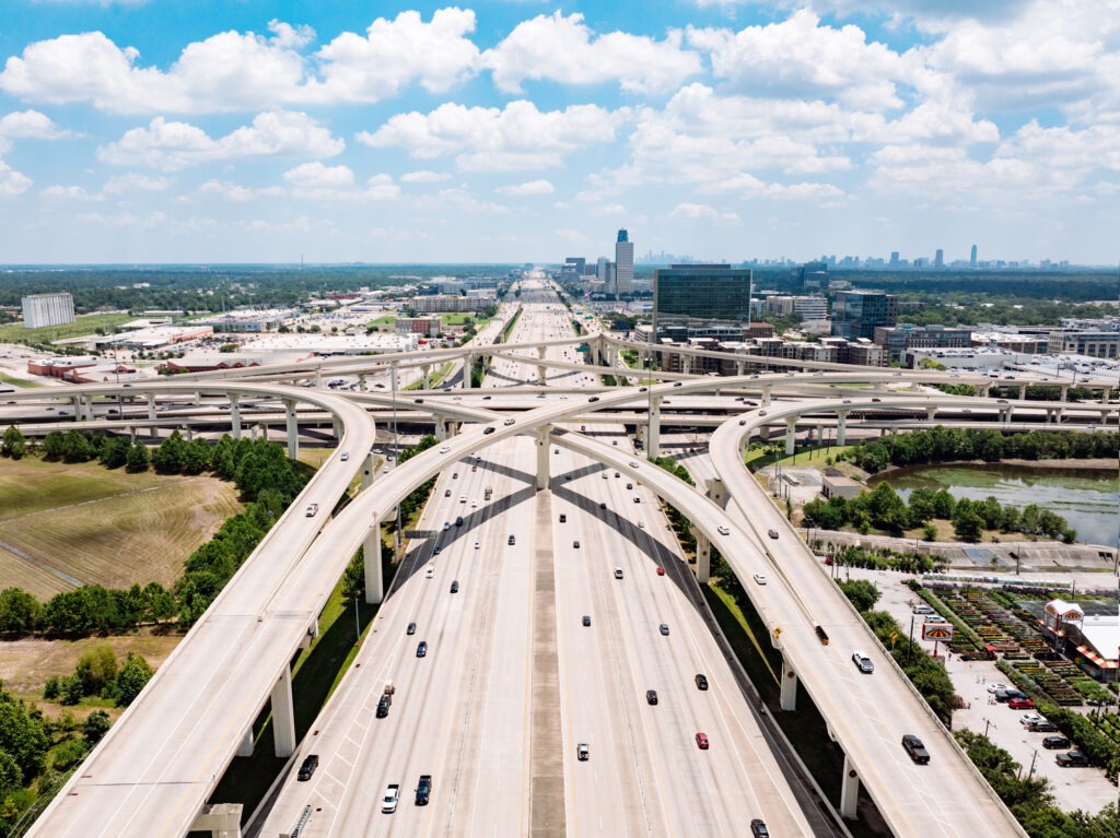 Drone point of view of traffic on the interstate, intertwining on ramps and off ramps.