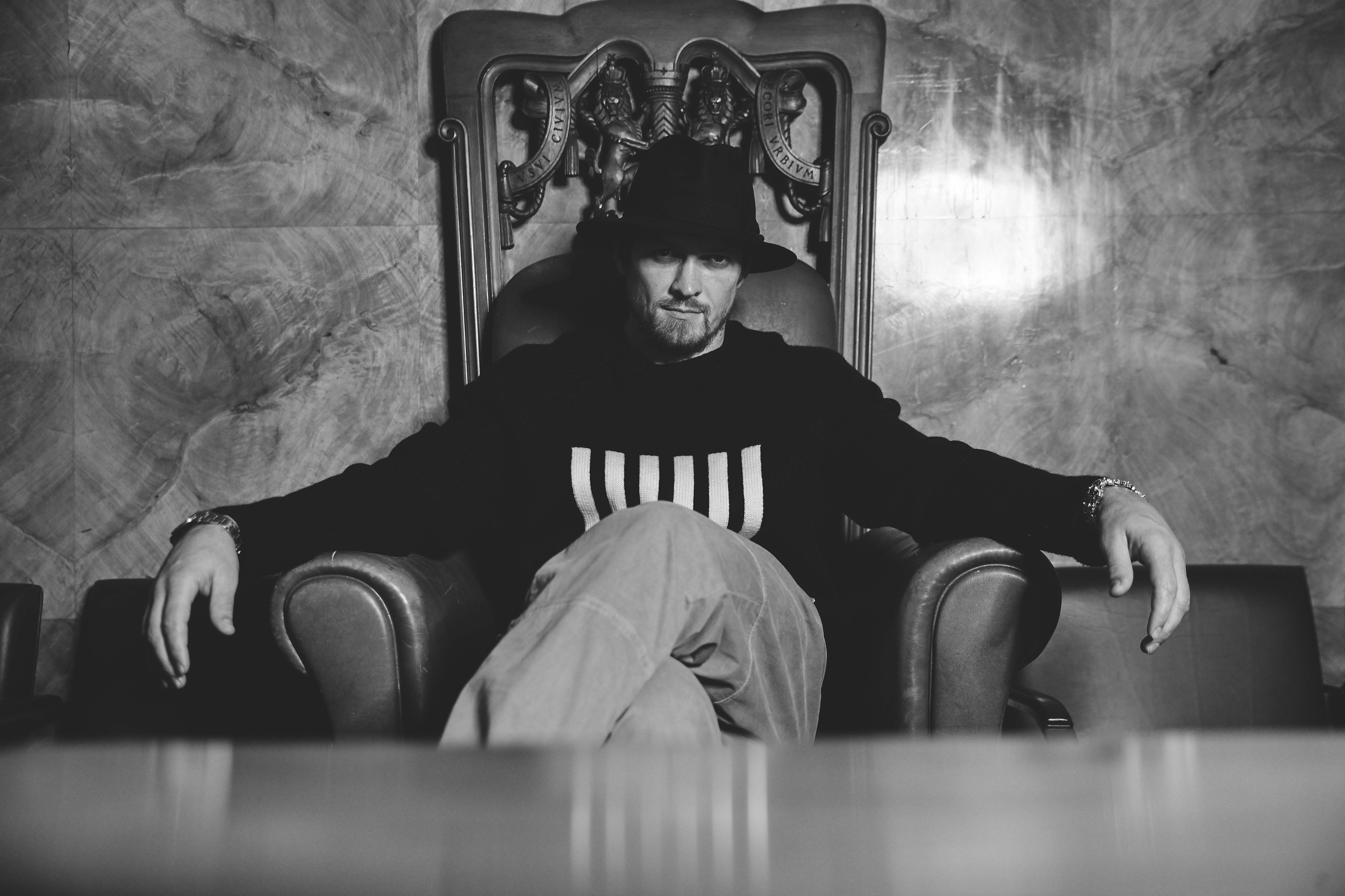 Black and white photo of Derek Chisora sitting in a chair.