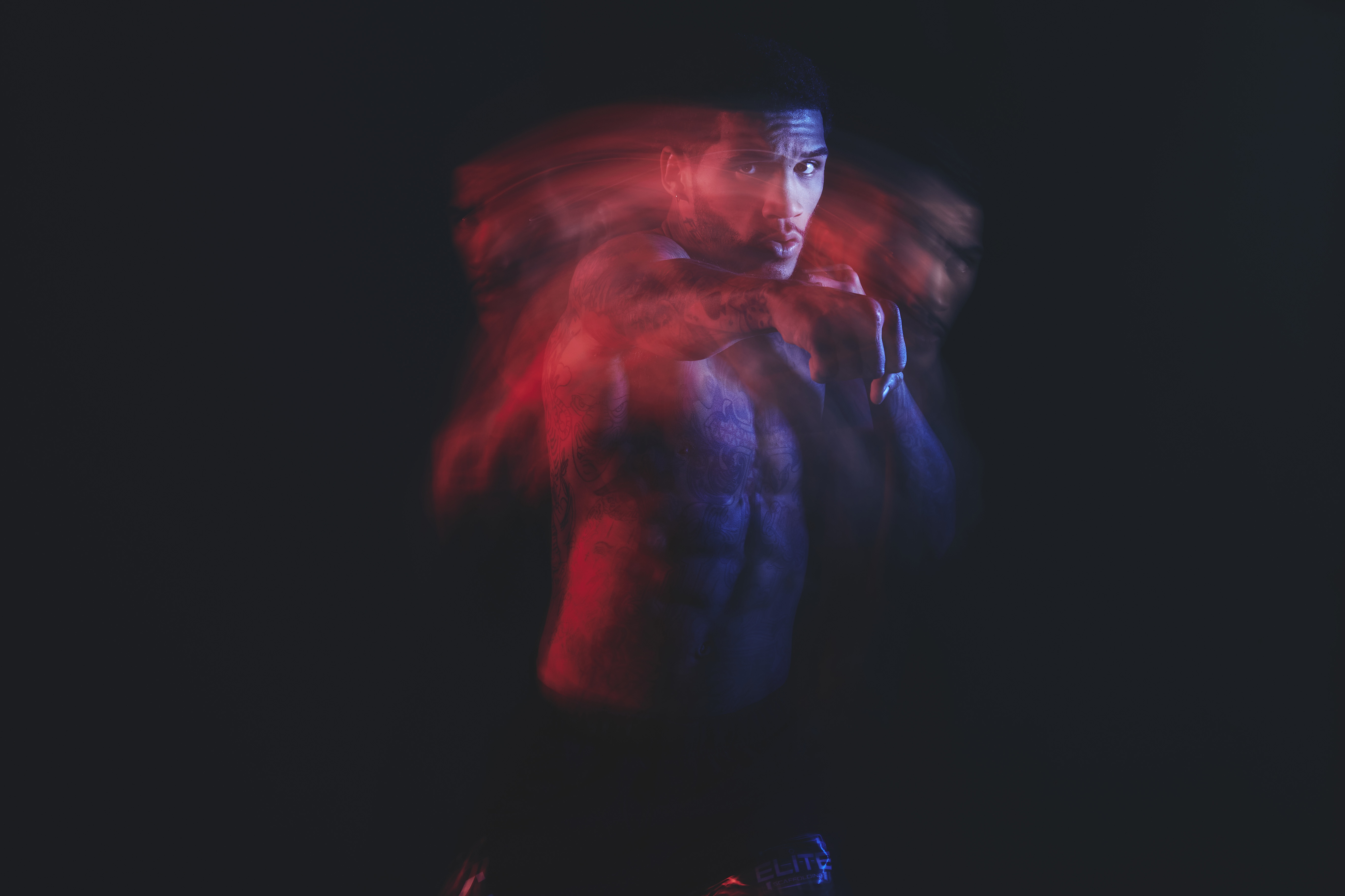 A shirtless boxer throwing a punch.