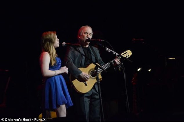 Lulu is seen singing with her father, Paul, of Simon & Garfunkel fame
