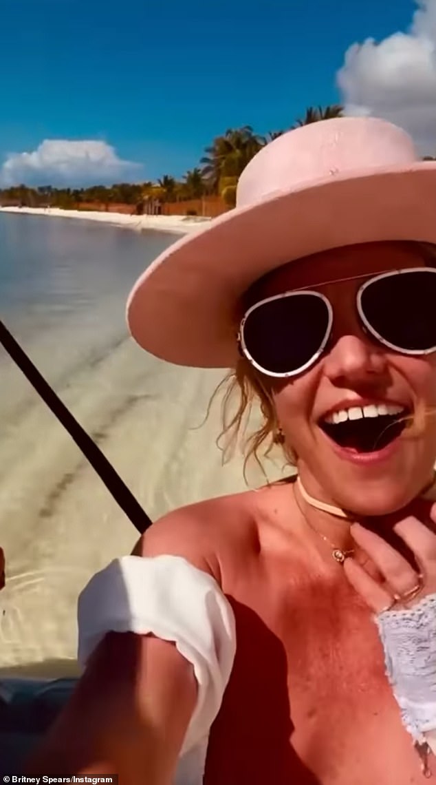 The Hold Me Closer hitmaker posted a second video of herself on the shoreline beside a mystery man and she's heard saying, 'Guys look, it gonna bite me!' before cheerfully thanking someone off camera