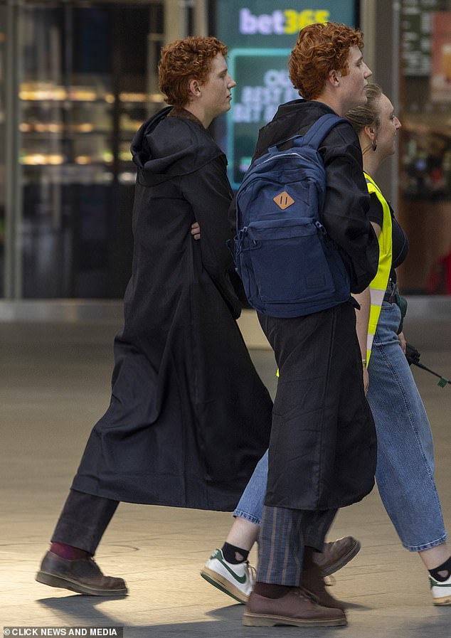 Tristan and Gabriel alsop wore long coats over their costumes during a break in shooting