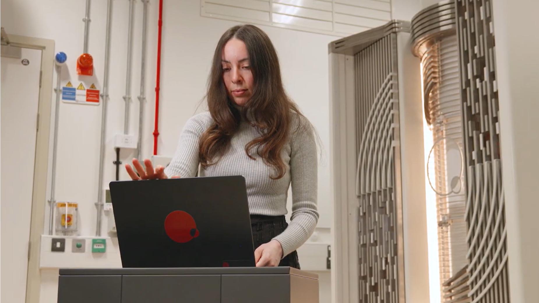 April Carniol, executive director at Quantum Motion, using a laptop.