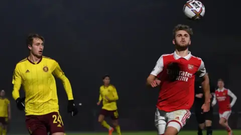 Getty Images Billy Vigar seen here during a match against Sparta Prague in 2022. Billy, in the Arsenal red and white kit, is looking at the ball which is in the air. 
