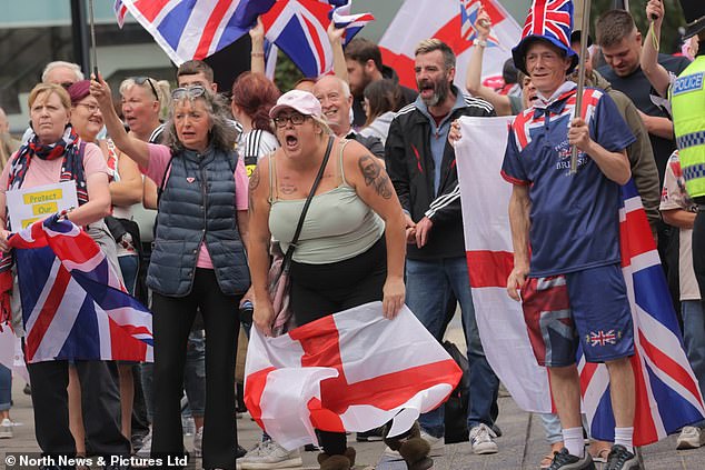 A protester displays a tattoo of Tommy Robinson on her arm as rival protest groups clash outside the New Bridge Hotel in Newcastle on Saturday