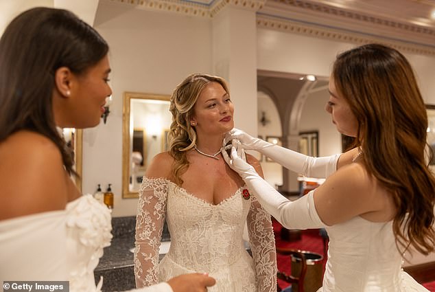 A trio of guests at the 2025 event on Saturday are seen helping each other out with their jewellery
