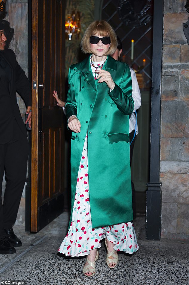 Anna Wintour looked glamorous in a cherry print dress that she paired with an emerald coat