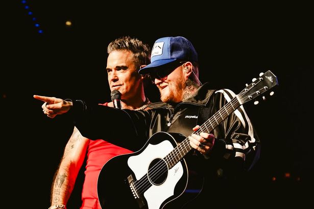 Robbie Williams on stage with Thom Rylance