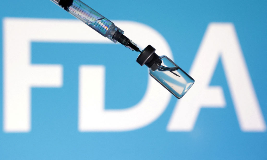 FILE PHOTO: Illustration shows U.S. flag, FDA logo, syringe and vial