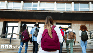 A resident walks with a shovel along a mud-covered road in Hualien on September 24, 2025, following the bursting of a barrier lake during the passing of Super Typhoon Ragasa.