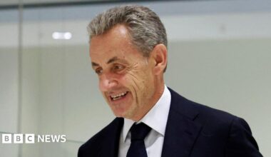A resident walks with a shovel along a mud-covered road in Hualien on September 24, 2025, following the bursting of a barrier lake during the passing of Super Typhoon Ragasa.