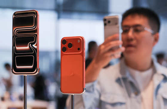 A man takes images of the new iPhone 17 Pro smartphones as they are displayed at the Apple store in Beijing's Sanlitun area during the start of sales on Sept. 19. [REUTERS/YONHAP]