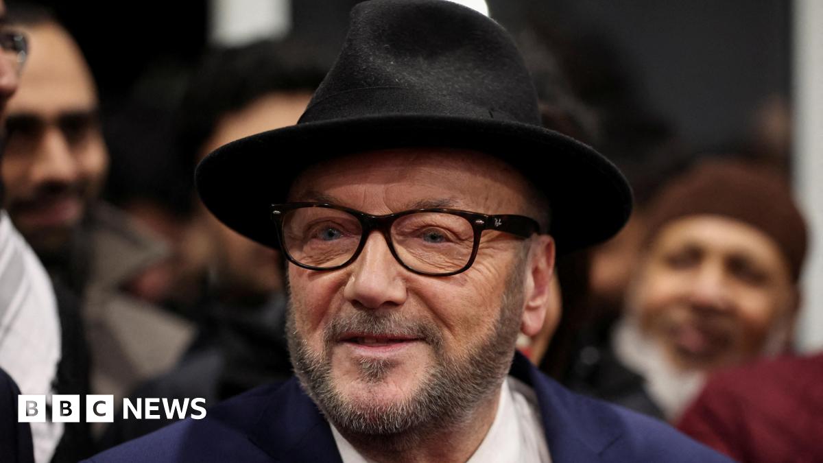 George Galloway, leader of the Workers Party of Britain wears a black felt fedora, raybans and a navy blazer.