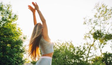 Woman doing wall angels in the garden wearing activewear among trees and sunshine