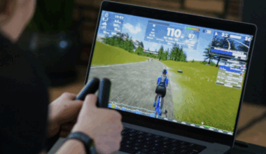 A view of a computer playing the racing simulation in front of a rider whose hands are only visible