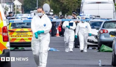 A resident walks with a shovel along a mud-covered road in Hualien on September 24, 2025, following the bursting of a barrier lake during the passing of Super Typhoon Ragasa.