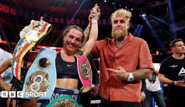 Ellie Scotney's hand is held up by Jake Paul