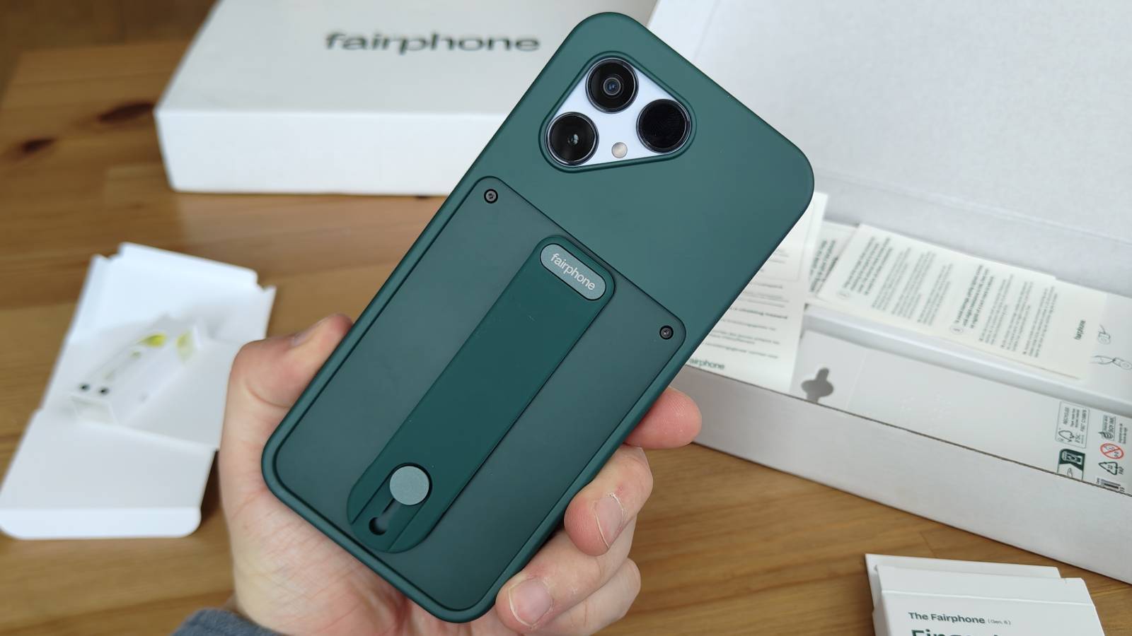 The Fairphone 6 with its case and finger grip attached.