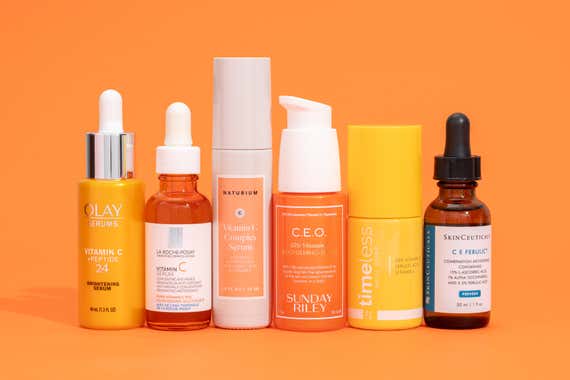 An assortment of vitamin C serums in different shapes and sizes lined up next to each other.