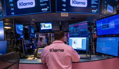 A man wearing a pink shirt with 'Klarna' written on the back