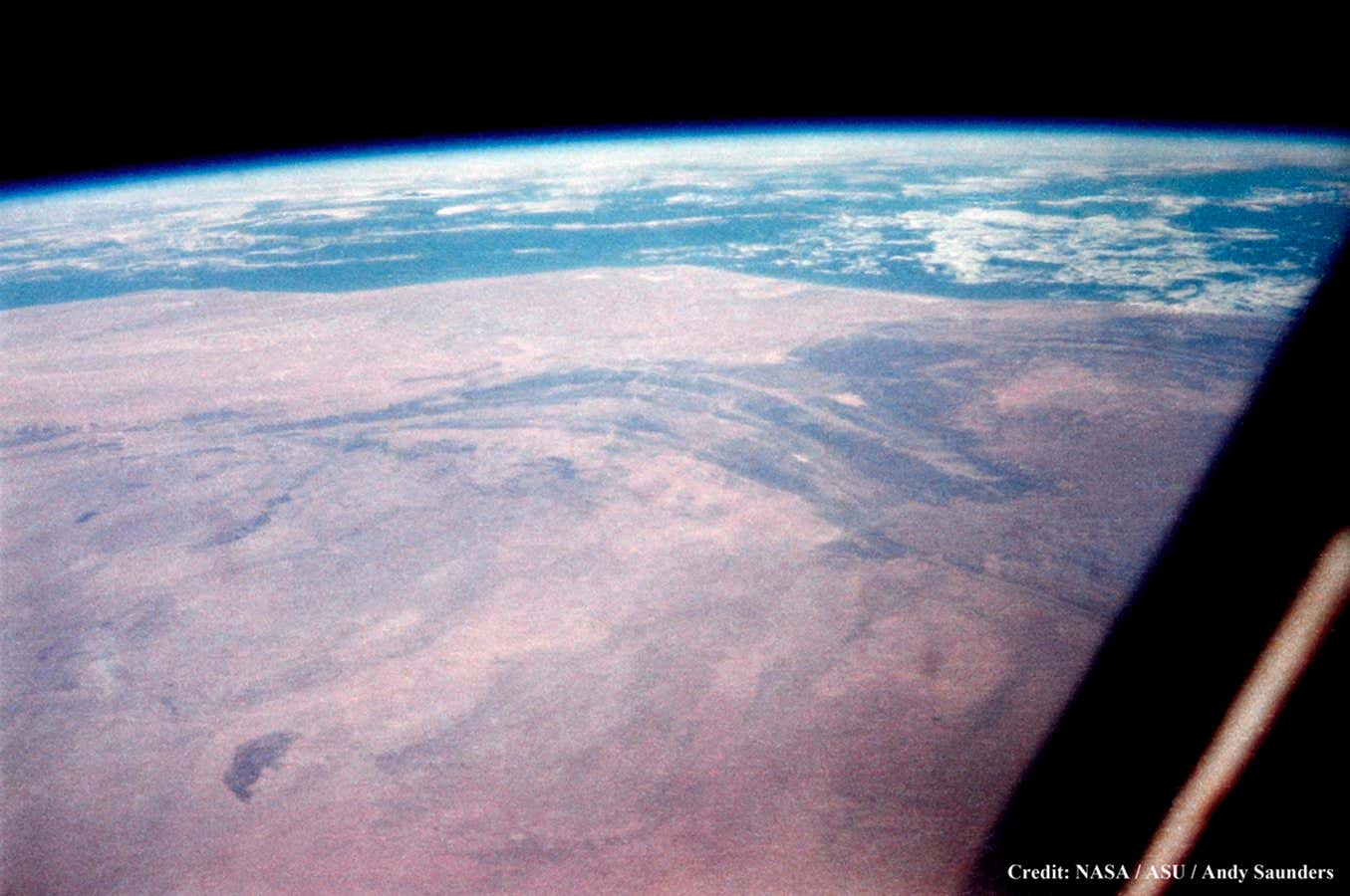 John Glenn lifts a $40 camera he bought himself from a local drugstore, points it through his small spacecraft window, and takes the first ever hand-held still photograph of Earth from space. 20th February, 1962.