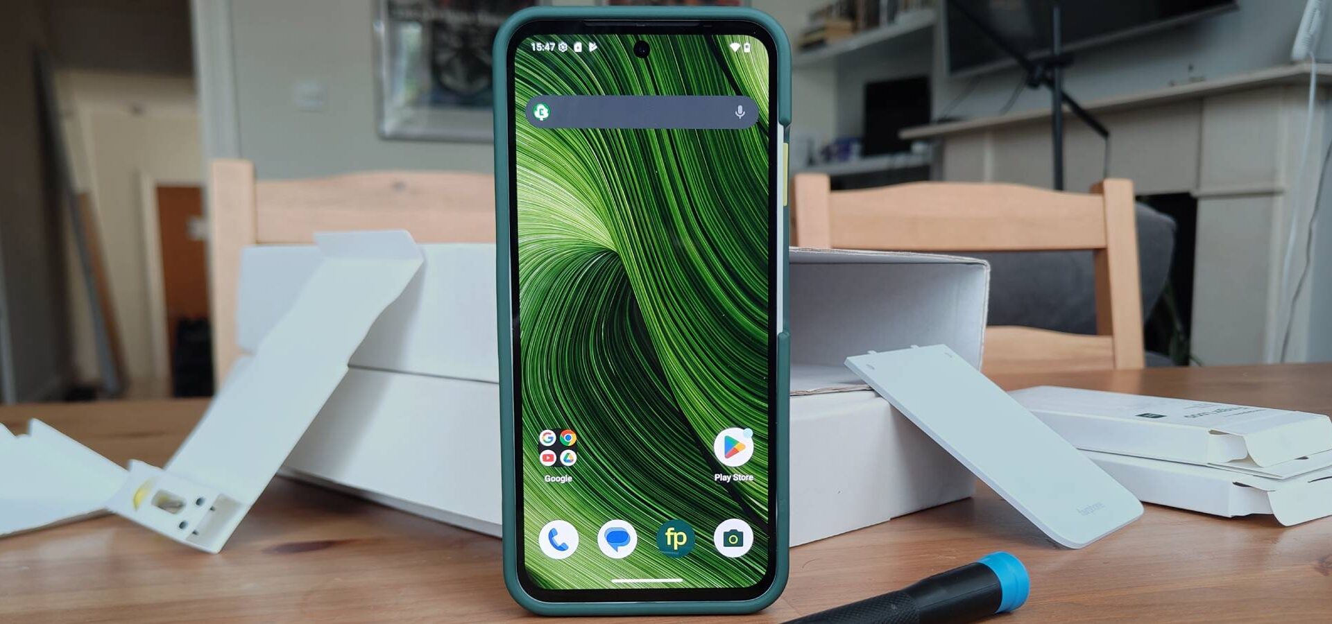 The Fairphone 6 standing before various boxes.