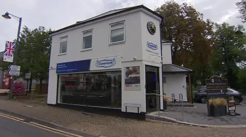 BBC Caremark's HQ in Crowthorne, a white building with a sign for High Street outside.