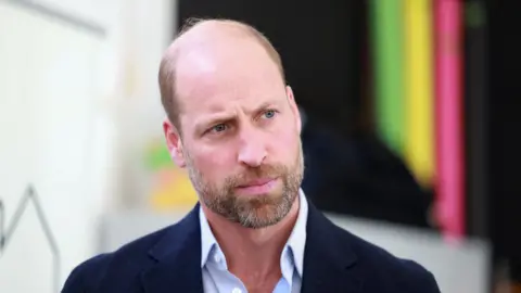 Getty Images Prince William looks to the right of the camera, he is wearing a light blue shirt with a navy blazer. 