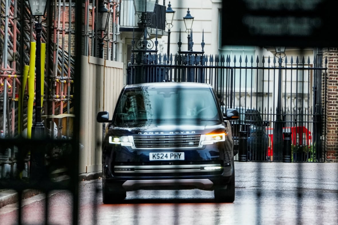 A black SUV drives down a  street