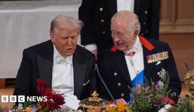 President Trump, wearing a tuxedo, sitting alongside King Charles at a banquet table at Windsor Castle.