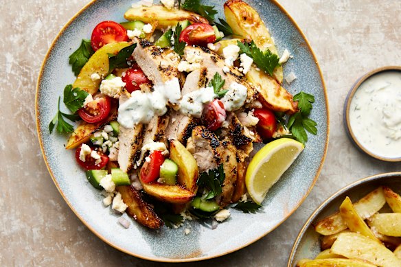 Chicken in a vibrant Greek-inspired marinade is served with tzatziki and potato wedges.
