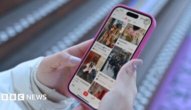 A resident walks with a shovel along a mud-covered road in Hualien on September 24, 2025, following the bursting of a barrier lake during the passing of Super Typhoon Ragasa.
