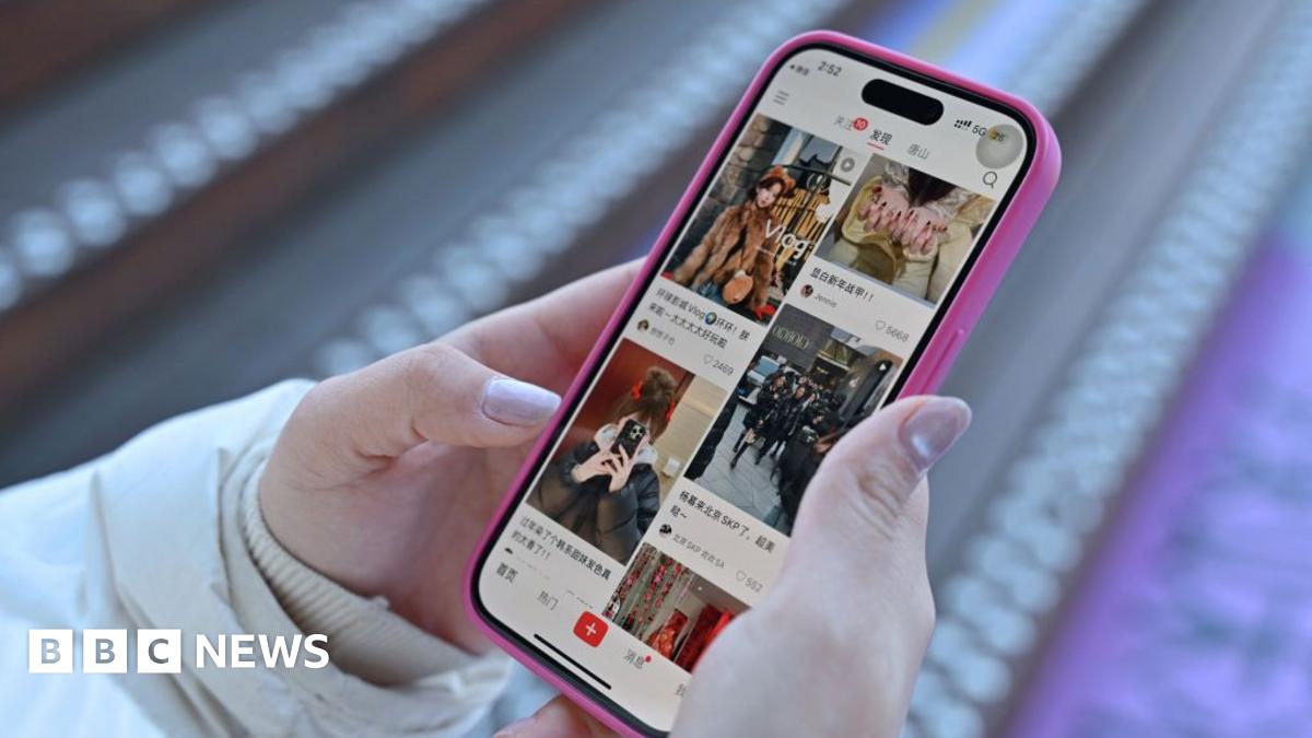A resident walks with a shovel along a mud-covered road in Hualien on September 24, 2025, following the bursting of a barrier lake during the passing of Super Typhoon Ragasa.