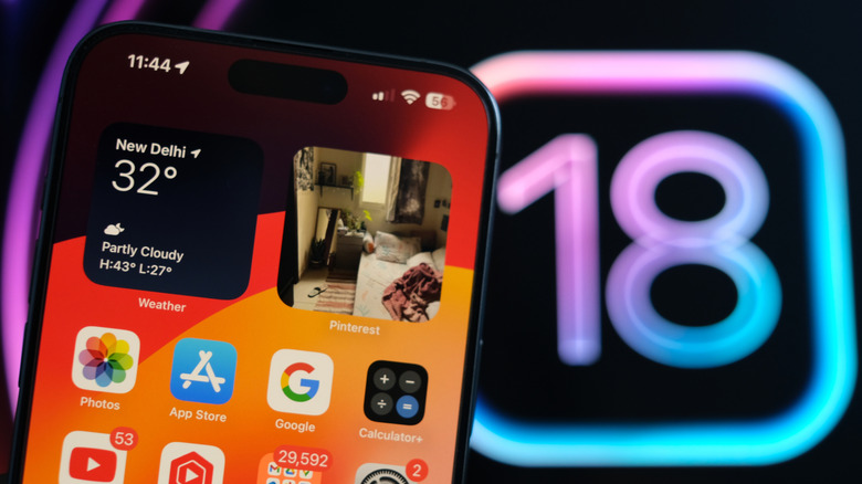 Close-up of an iPhone with the iOS 18 logo in the background
