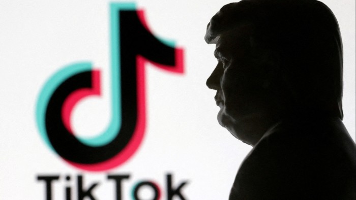 A 3D-printed miniature model of Donald Trump is shown next to the TikTok logo