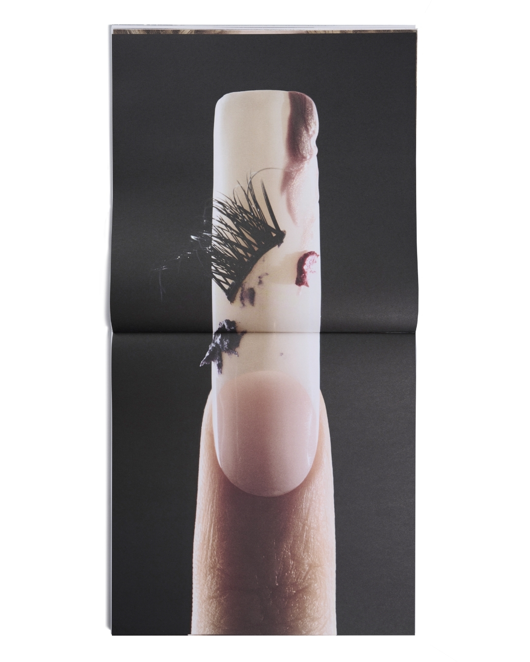 Nail with fake eyelashes and lipgloss smears