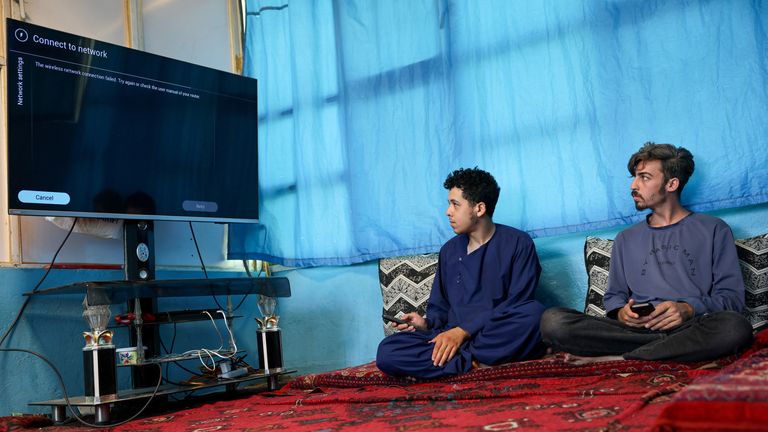 Men try to connect their smart TV to the internet. Pic: Reuters