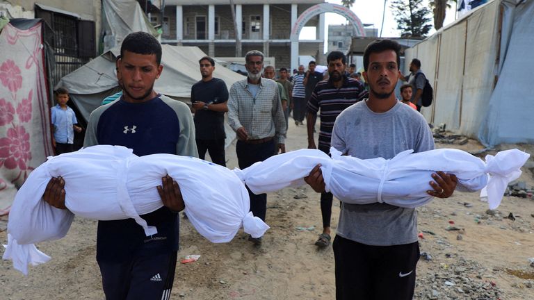 Men carry the bodies of Palestinian children killed in a strike on a building where people were sheltering in Gaza City. Pic: Reuters
