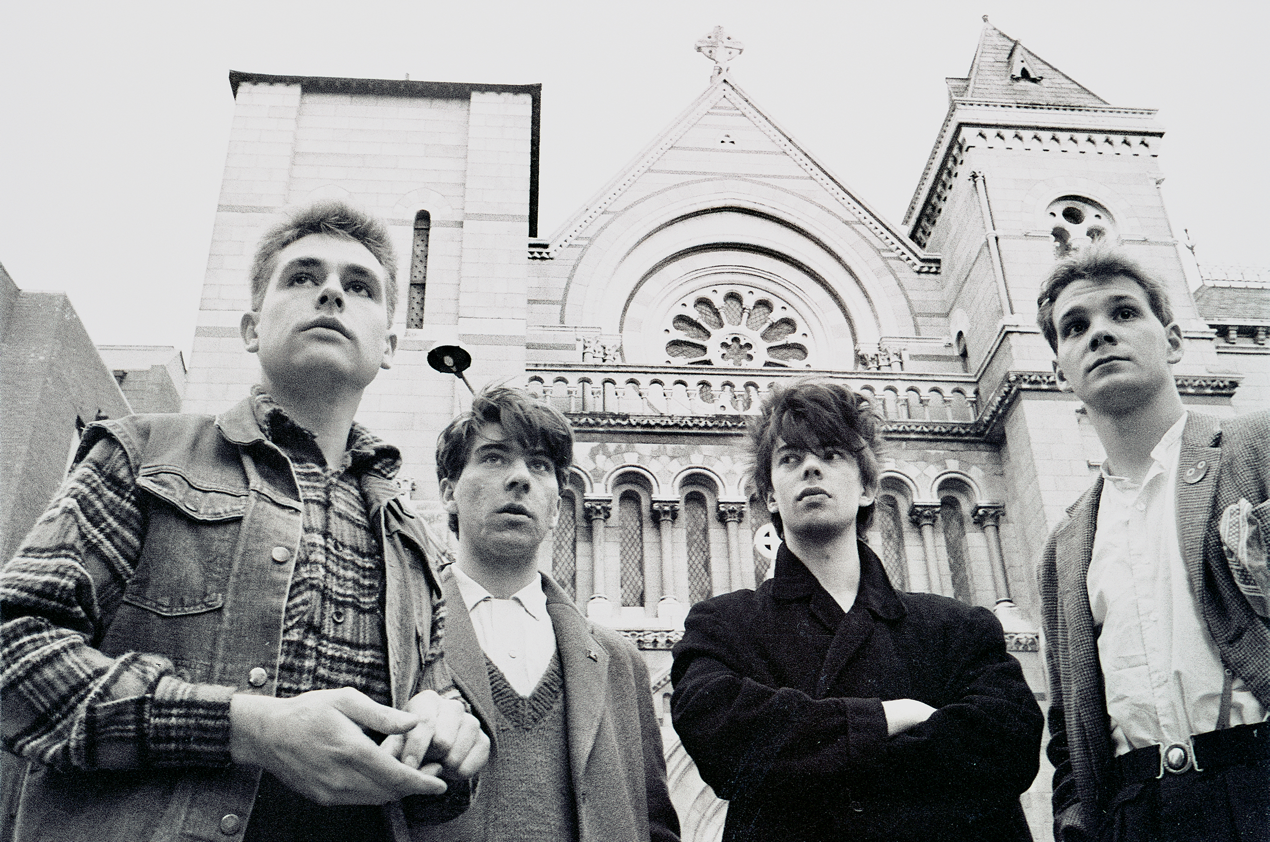 Four young men standing in front of a magnificent church