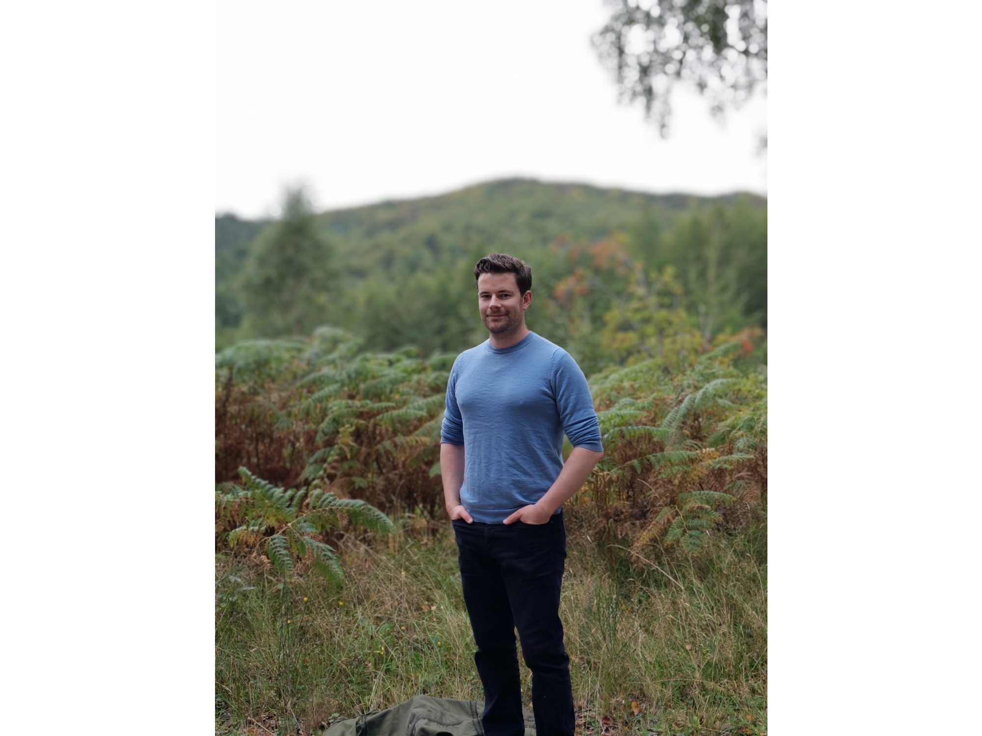 A camera sample taken on the Fairphone 6 showing a man before a forest.