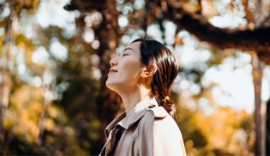Woman looking up into autumnal trees