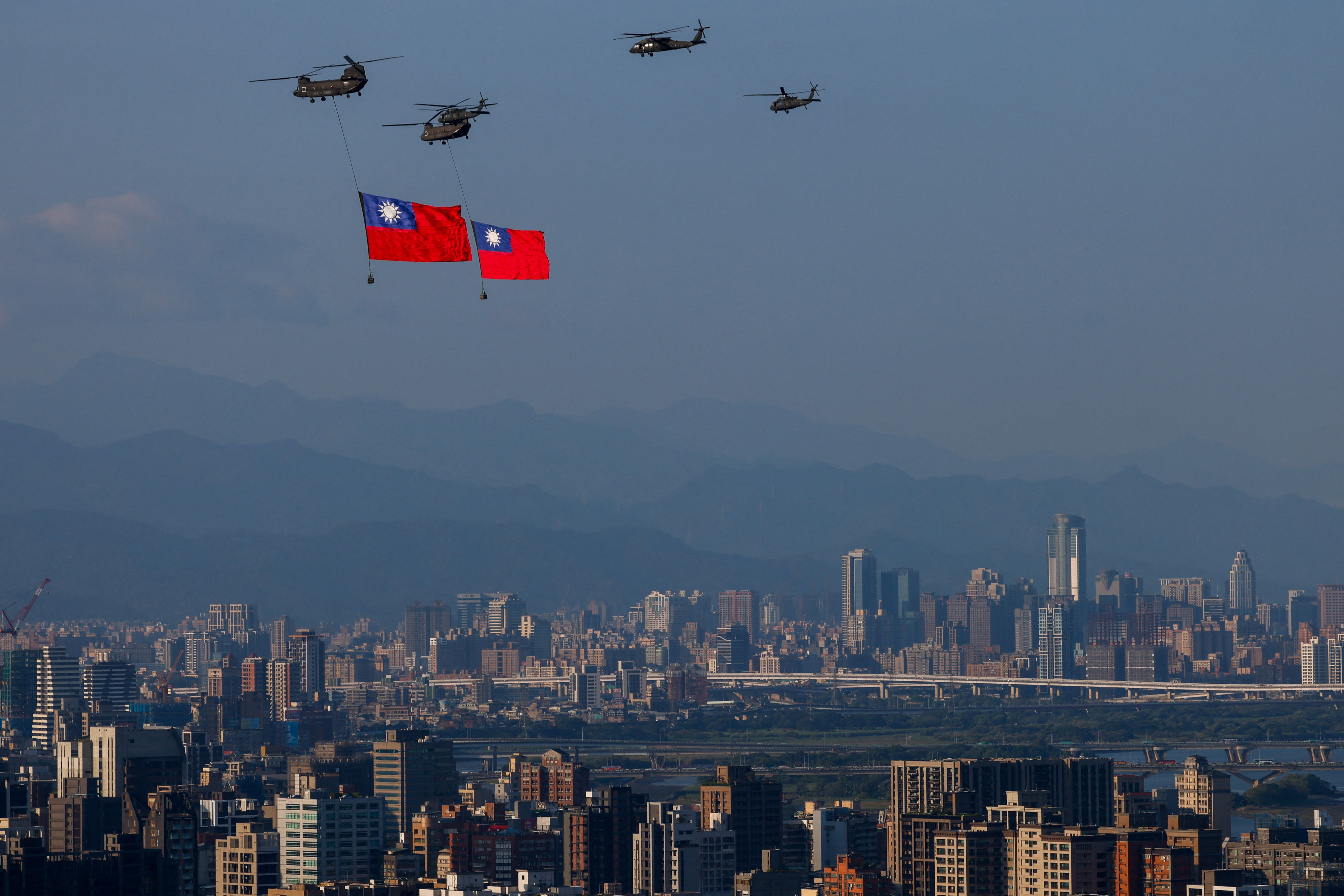 Boeing CH-47SD helicopters carries Taiwan's national flag as UH-60 Black Hawk helicopters fly alongside during a rehearsal